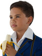 Schoolboy looking away while eating banana