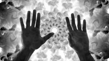 Computer Graphics And Double Exposure. A Kaleidoscope Of Swirling Smoke Against Which Two Male Hands Rise, Palms Forward, And Their Fingers Intertwine. Strange Concept