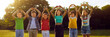 © Studio Romantic - Group of happy cheerful cute little children having fun in green sunny summer park, standing in row, smiling, raising hands up and doing heart gestures together. Banner, header. Love and peace concept