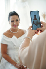 Wall Mural - Mother photographing daughter in wedding dress