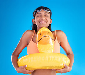 Sticker - Smile, goggles and rubber duck with a woman on a blue background in studio ready for summer swimming. Happy, travel and vacation with an attractive young female feeling excited to relax or swim