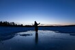 Silhouette of a young kid standing on the ice in the mountains in winter
