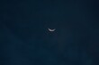 Beautiful crescent moon barely visible in a blue night sky