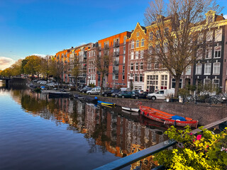 Wall Mural - Amsterdam canal view with boats and bicycles at sunset, Netherlands