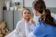 © Halfpoint - Young doctor taking care of little girl in hospital room.