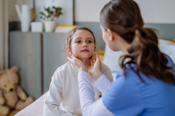 Wall Mural - Young doctor taking care of little girl in hospital room.