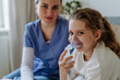 © Halfpoint - Little girl with inhaler in hospital room, nurse chcecking her.