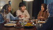 © tirachard - Happy Asia muslim parent and their kids Ramadan dinner together in dining room at home. Family of two generation catering celebration end of Eid al-Fitr togetherness at home. Hari Raya family reunion.