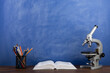 © Sensay - Back to school - books and microscope on the desk, Education concept. Blackboard background