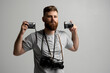 © Volodymyr - Handsome and confident bearded man photographer with a professional cameras ready in a hand for take a picture.