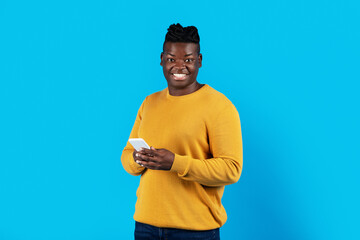 Poster - Portrait Of Millennial Black Man Holding Mobile Phone And Looking At Camera