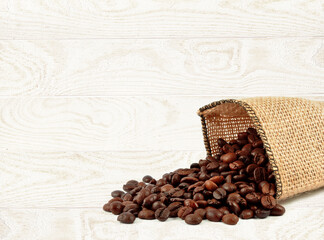 Wall Mural - coffee beans in a bag on a light wooden background