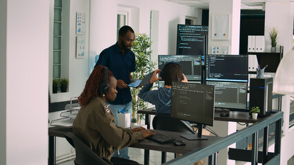 African american focused software engineer working on computer screen and typing in it office. Database programer writing code with algorithms, using new server interface on terminal window.