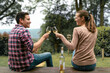 © kieferpix - Young happy couple enjoying glass of wine celebrating outdoors in nature setting