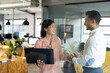 © Wavebreak Media - Diverse happy business people using laptop, holding documents and discussing, working late at office