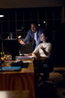 © Wavebreak Media - Diverse business people sitting at desk, using computer for video call, working late at office