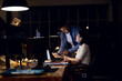 © Wavebreak Media - Diverse business people sitting at desk, using tablet and discussing, working late at office