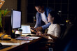 © Wavebreak Media - Diverse business people using computer with copy space on screen, working late at office