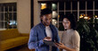 © Wavebreak Media - Diverse business people using tablet together and discussing, working late at office