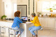 © Wavebreak Media - Multiracial lesbian couple analyzing bills over laptop while having coffee on kitchen island