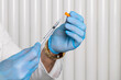 © Georgi - Close-up of doctor's hands in clean or sterile gloves preparing a syringe or vaccine for an injection.