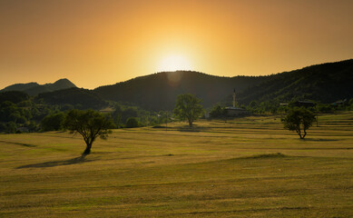 Sticker - A rural village in Türkiye at sunset. Farmland and mosque. A beautiful mountain village.