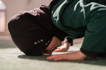 Wall Mural - A female Muslim prayer praying inside the mosque.