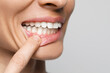 © New Africa - Woman showing healthy gums on light background, closeup. Space for text
