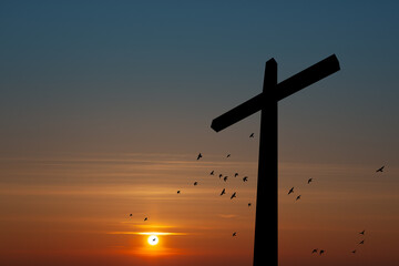 Wall Mural - Christian cross with flying birds at sunrise. Resurrection of Jesus. Concept photo.
