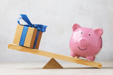Piggy bank and gift box on the scales, a concept on the topic of saving money for gifts