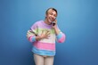 © Ivan Traimak - cheerful blond young woman in a striped jacket communicates by voice on a smartphone on a blue background