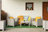 Fototapeta Panele - Beautiful rattan garden furniture, soft pillows, blanket and yellow chrysanthemum flowers outdoors