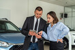 © RomanR - Young  male car shop assistant working with digital tablet with his client in dealership