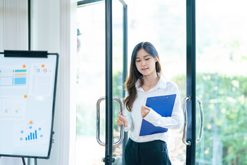 Businesswoman opening door while entering modern building