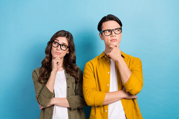 Poster - Photo of doubtful serious husband wife dressed shirts eyewear arm chin looking empty space isolated blue color background