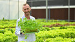 © Prathankarnpap - Portrait of Agricultural scientists holding crate of seedlings standing in industrial greenhouse