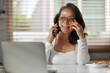 © Prathankarnpap - Positive senior woman in glasses having pleasant phone conversation and looking through window