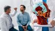 © Peakstock - Neurology, conceptual image. Anatomical model of human head with vascular structures and nerves in foreground of neurologist's consultation with patient in hospital