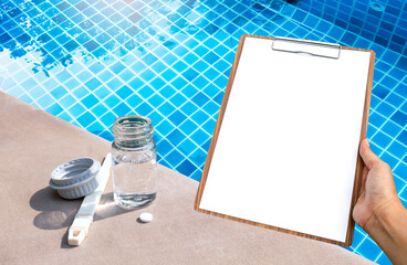 Wall Mural - Glass bottle with white tablet and girl hand holding clipboard over swimming pool, Swimming pool water testing report