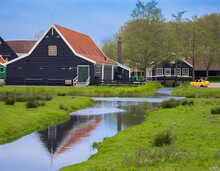 Zaanse Schans, Netherlands - April 25, 2022: A Tranquil Residential District In Holland, Zaanse Schans Is A Beautiful Landscape Of Grassy Fields, Trees And Water Featuring Iconic Dutch Architecture.