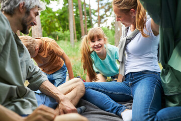 Wall Mural - Happy siblings with family in tent during vacation