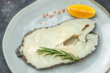 Wall Mural - Fillet of fresh sea white cod fish steak Anarhichas on plate. banner, menu, recipe place for text, top view