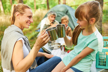 Wall Mural - Mother and daughter toasting mugs at forest in summer