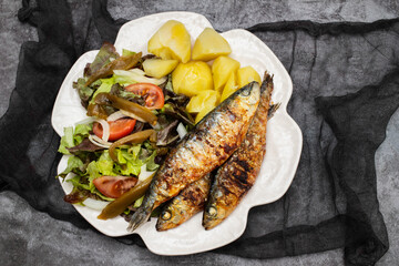 Wall Mural - Grilled sardines with boiled potato and fresh salad