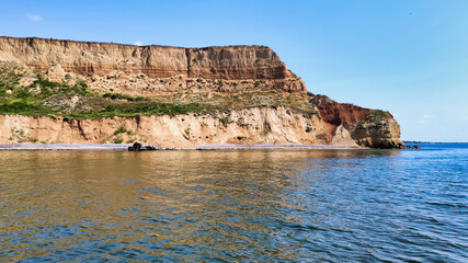 Wall Mural - View of the Black Sea and colorful clay cliffs with green grass near Koblevo. Ukraine. Europe	