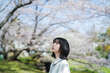 桜の花を見るショートヘアの女性