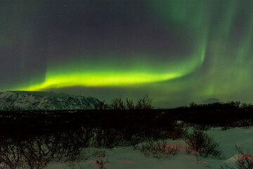 imagen de un paisaje nocturno nevado con una aurora boreal en el cielo de islandia