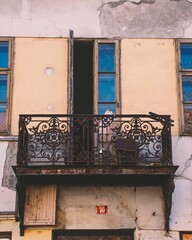 Vertical shot of an old building balcony with a half-open door