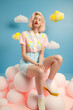 © Uncanny Valley - A young, beautiful girl who is in the clouds, thick white clouds on clear blue sky. A symbol of happiness, joy and freedom, a cute girl in a pastel outfit. Generative AI.