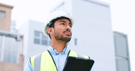 Poster - Construction worker holding a digital tablet while doing inspection. Organized male engineer or technician in a hardhat checking project plan with latest tech. Worker looking or overseeing operations